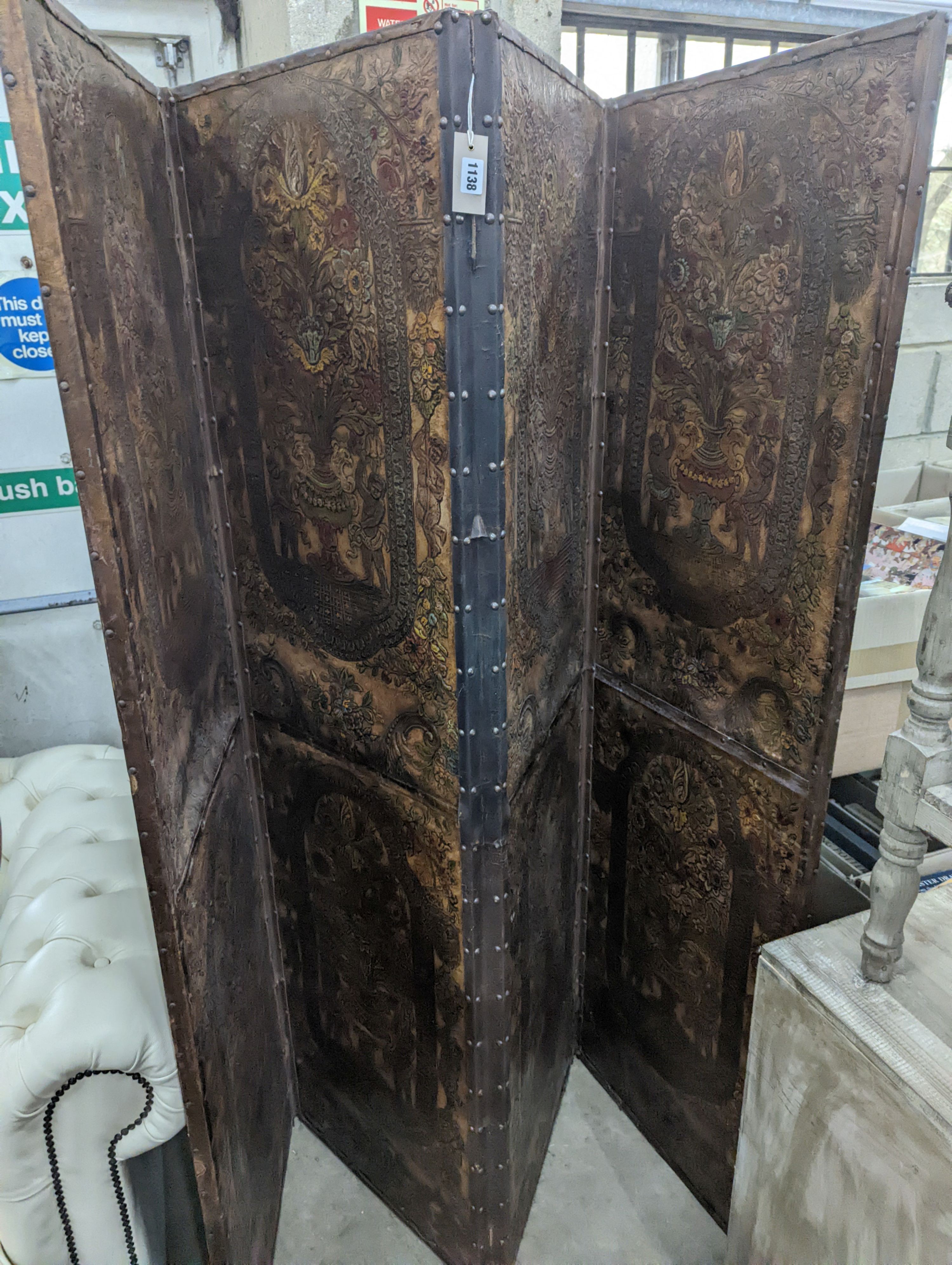 An embossed leather four fold dressing screen, each panel width 51cm, height 181cm